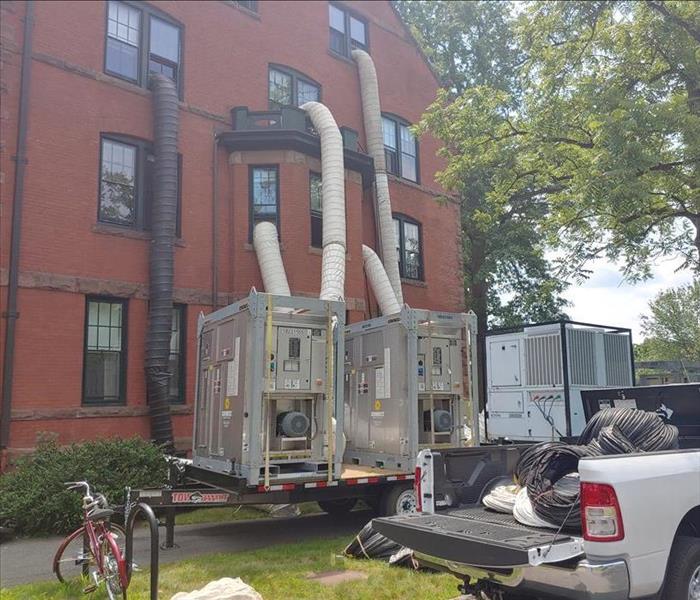 Water removal equipment with white tubes going into a building