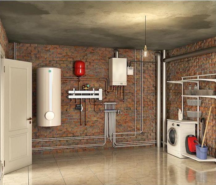 Standing water in a basement with red brick walls and tanks and pipes. 